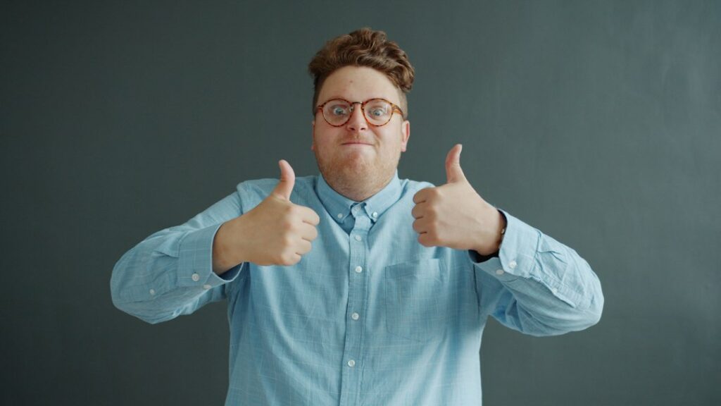 Man with glasses gives two thumbs up
